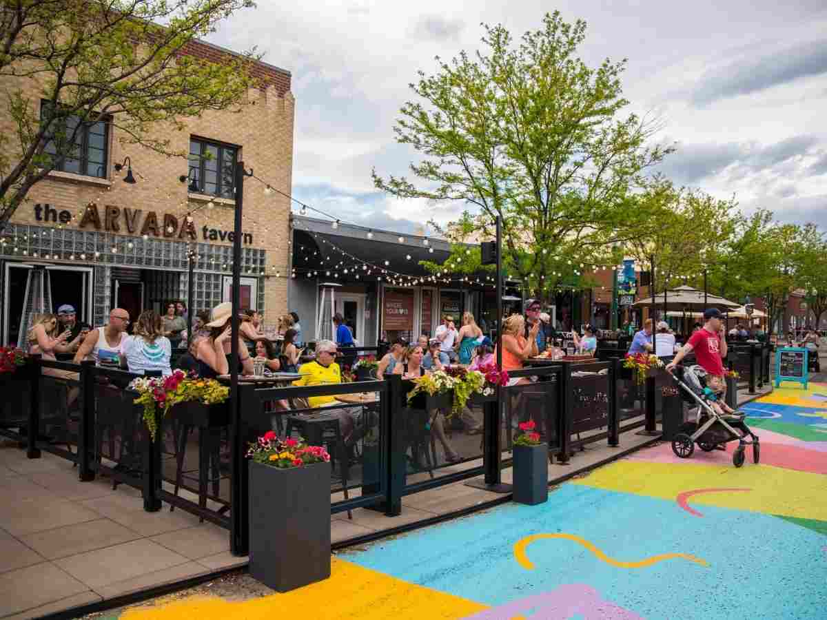 Outdoor cafe with chalk on street for article Arvada Colorado for newcomers moving to Denver Metro area.