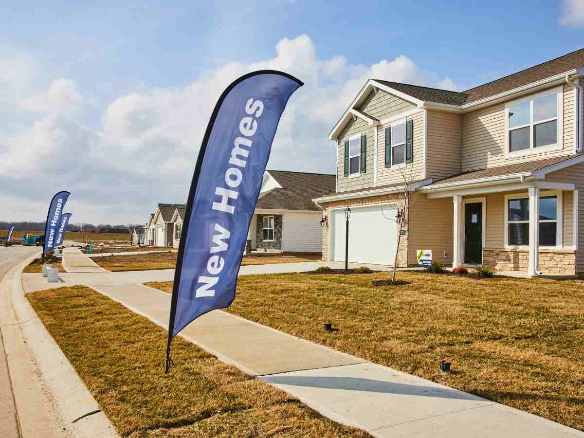 Street of new homes with banner in front of each that says new homes for article New Home builders in Northern Colorado for newcomers moving to Northern Colorado.