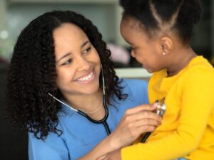 Doctor with stethoscope listening to child's heart for article Healthy Kids in Denver for newcomers moving to Denver area.