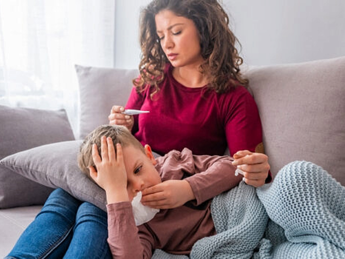 Picture of mom holding sick child for article Cold, Flu or COVID-19? How to tell