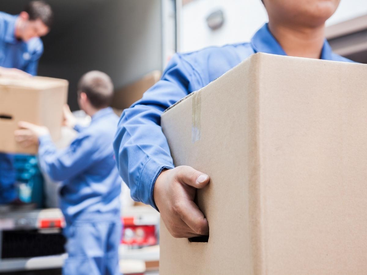Professional movers unloading and carrying boxes for article Denver Area Moving and Storage for newcomers moving to Denver area.