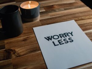 Worry Less message on a wooden table for article New Years resolution in Denver for newcomers moving to the Denver area.