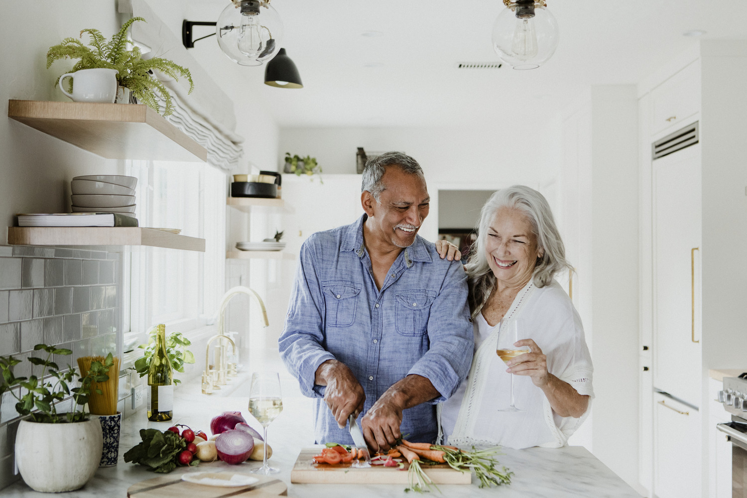 Department Image: RETIRE. Older couple cooking together in kitchen