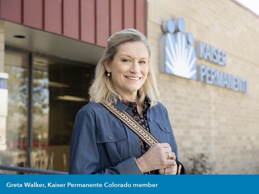 woman standing and smiling in front of Kaiser Permanente building in the daytime