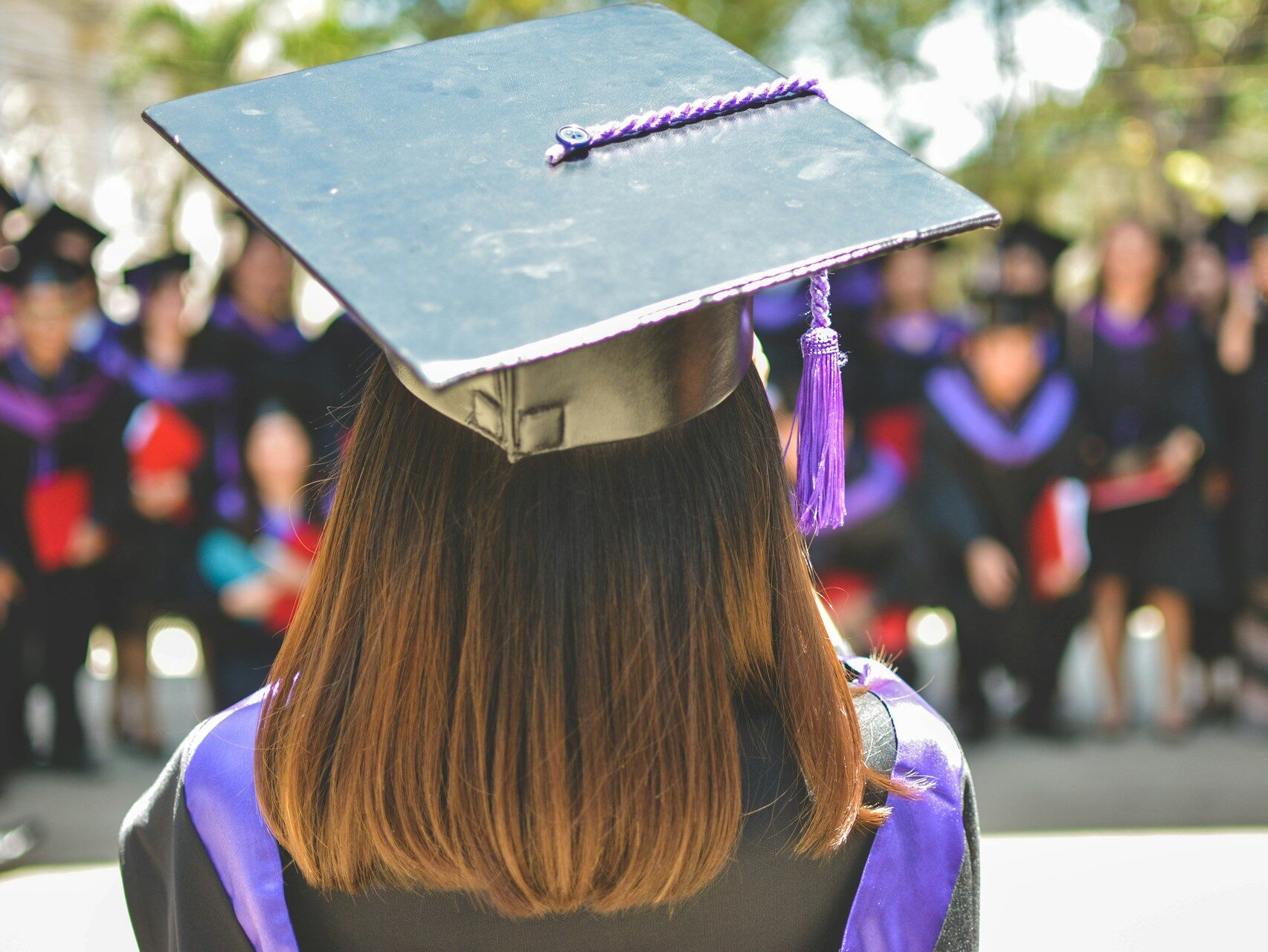 a female graduate standing on stage giving a speech during her graduation