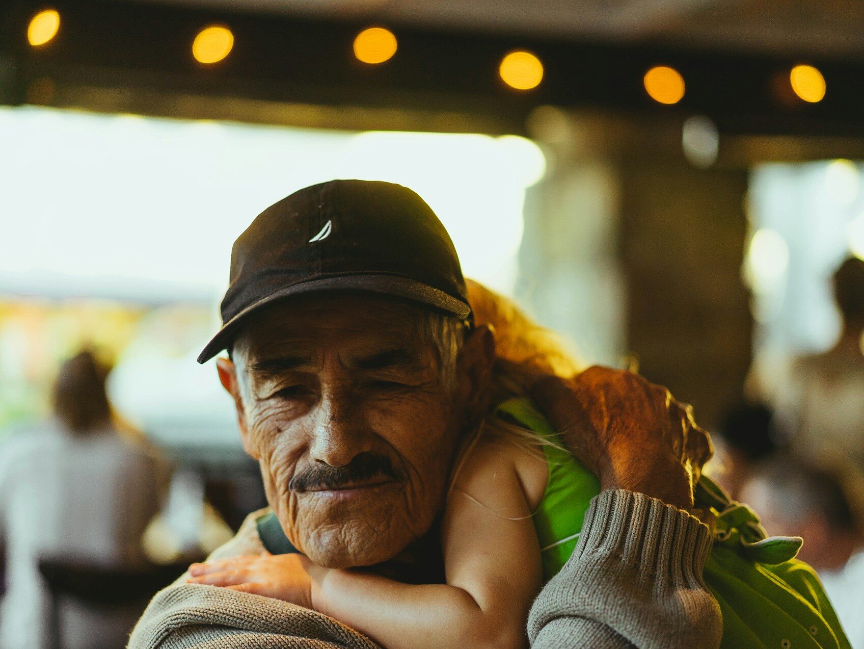 a grandfather holding his granddaughter with a loving smile on his face