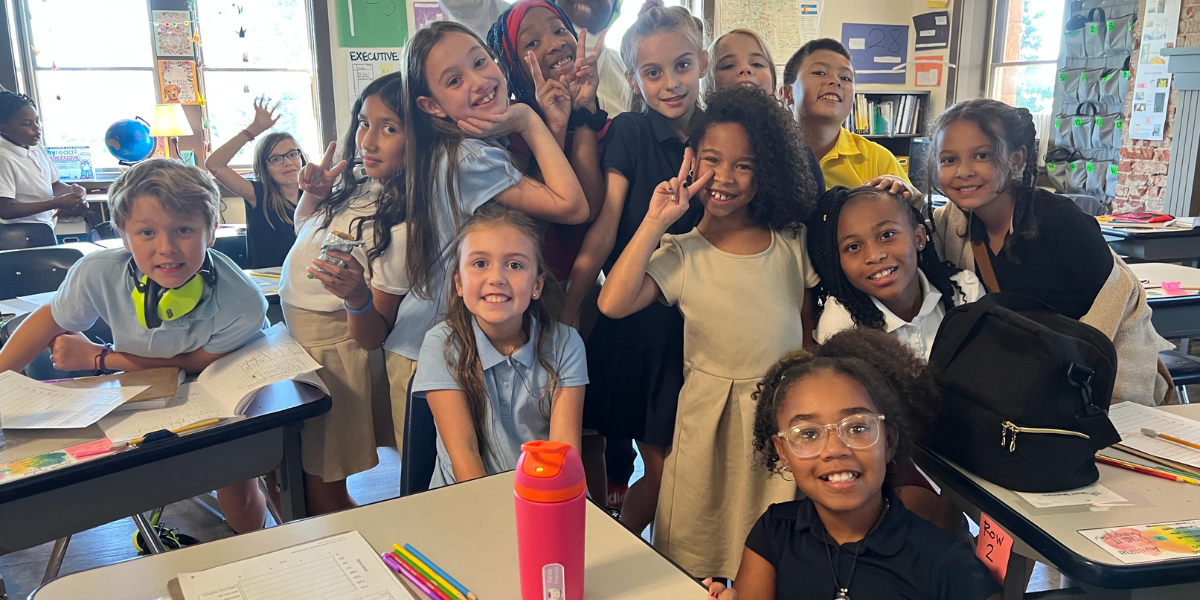 group of kids in classroom posing and smiling for camera