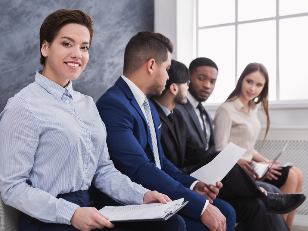 Young professionals sitting in a waiting room getting ready to be called for a job interview.