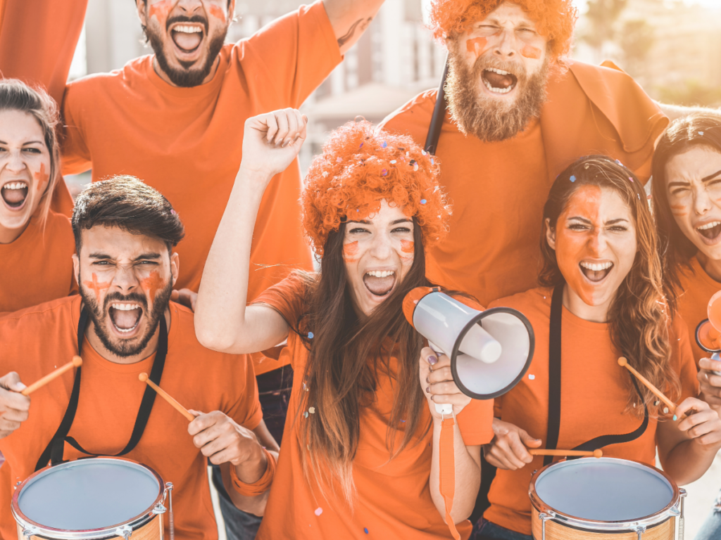 Group of people cheering at a sporting event.