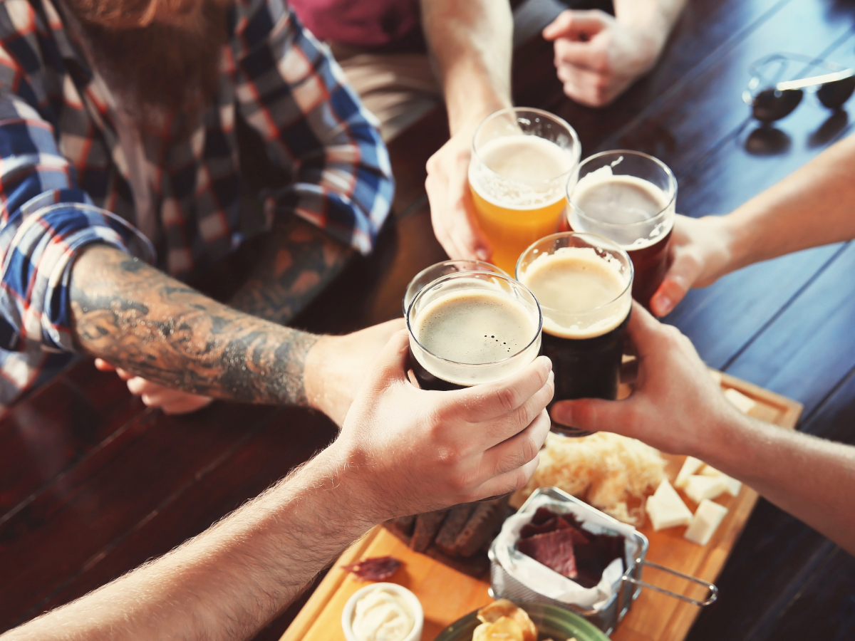 Cheers with close-up of different craft beers in beer pint glasses.