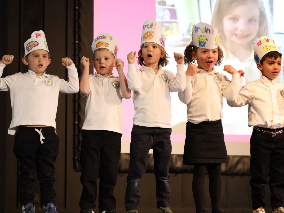 Aspen Academy kids on stage presenting.