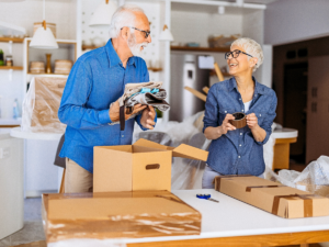 Senior man and woman sorting and packing to move while laughing and smiling.