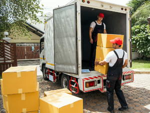 Professional movers moving boxes out of moving truck.