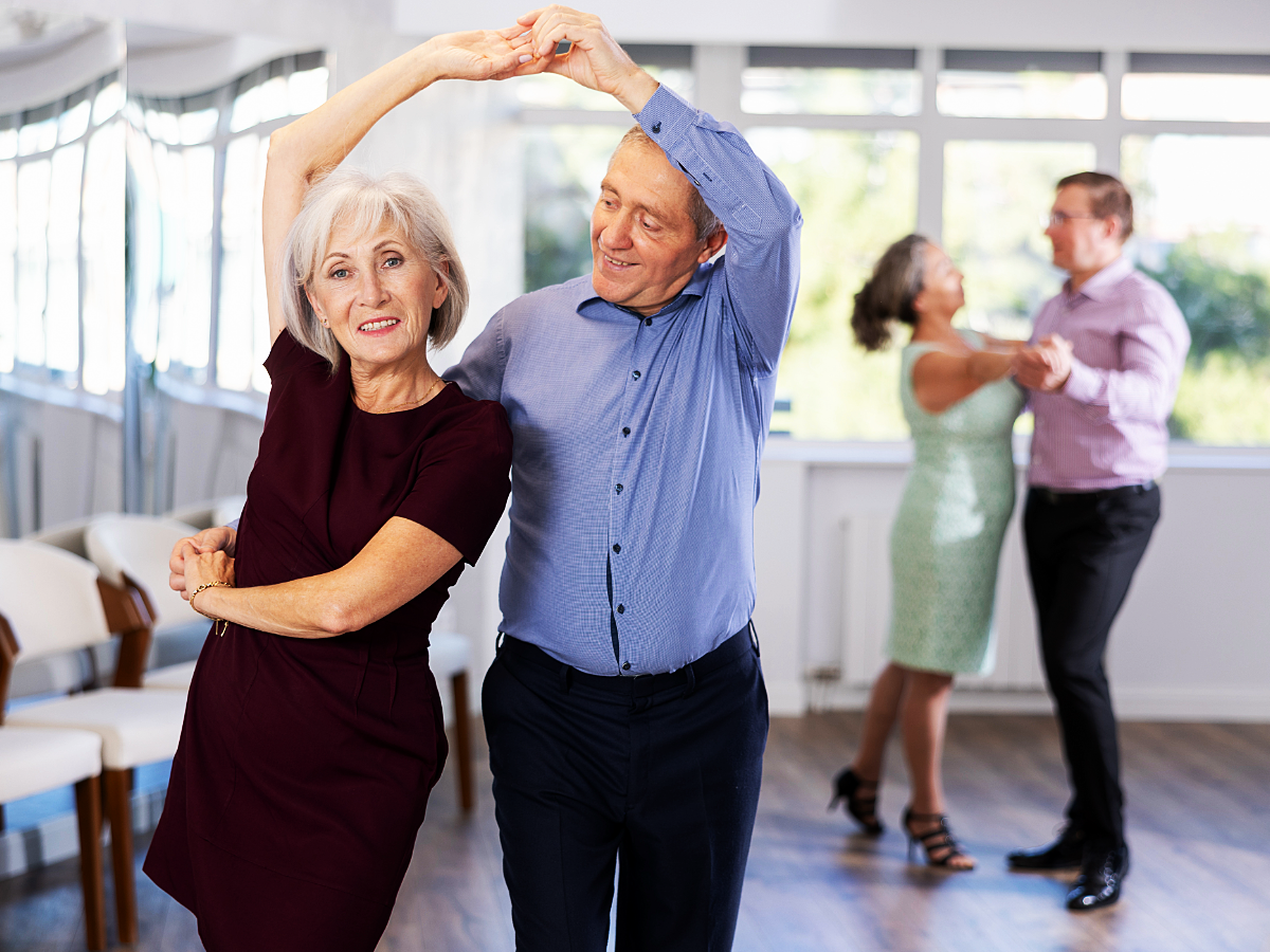 Senior adults learning to dance in a class.