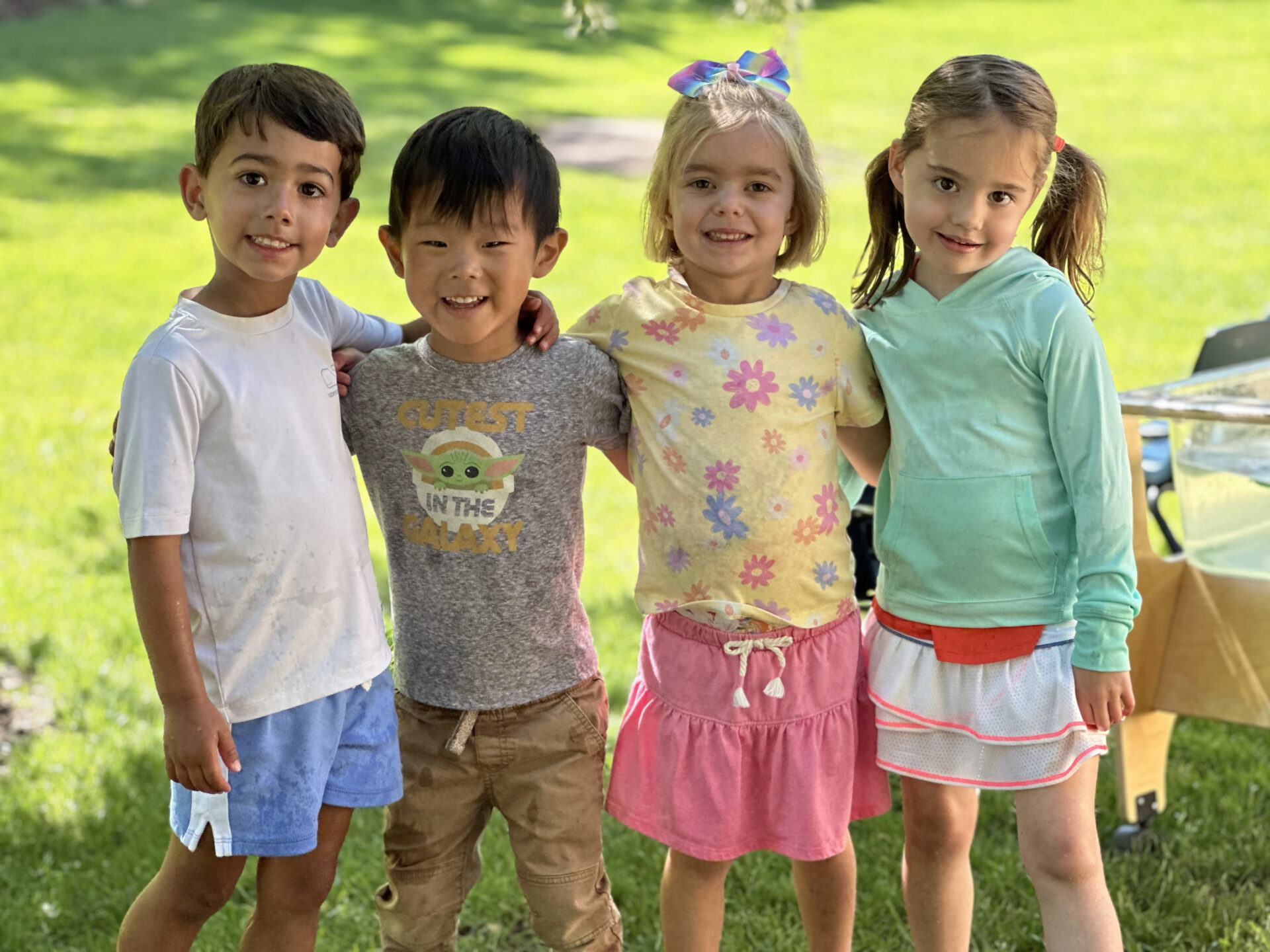 4 St Anne's students posing together outside on a warm summer day.