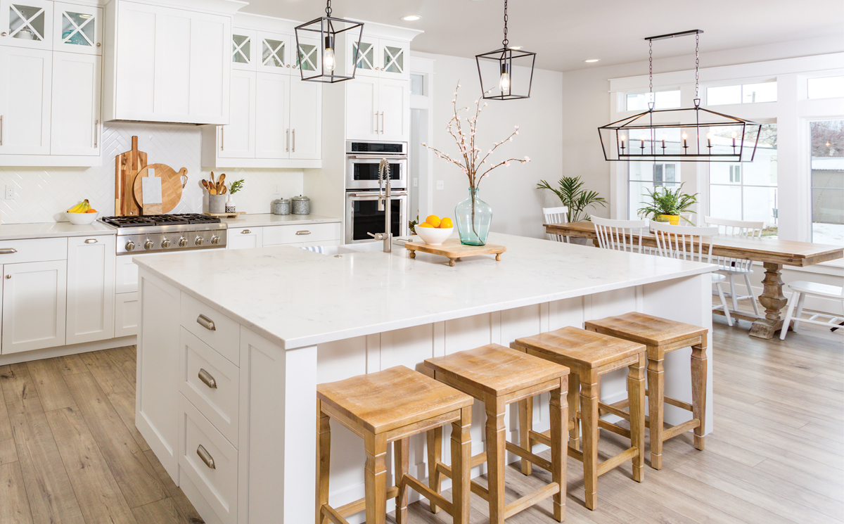 Modern white kitchen with large island for article - Chatting About a Changing Market for Newcomers Moving to Denver.