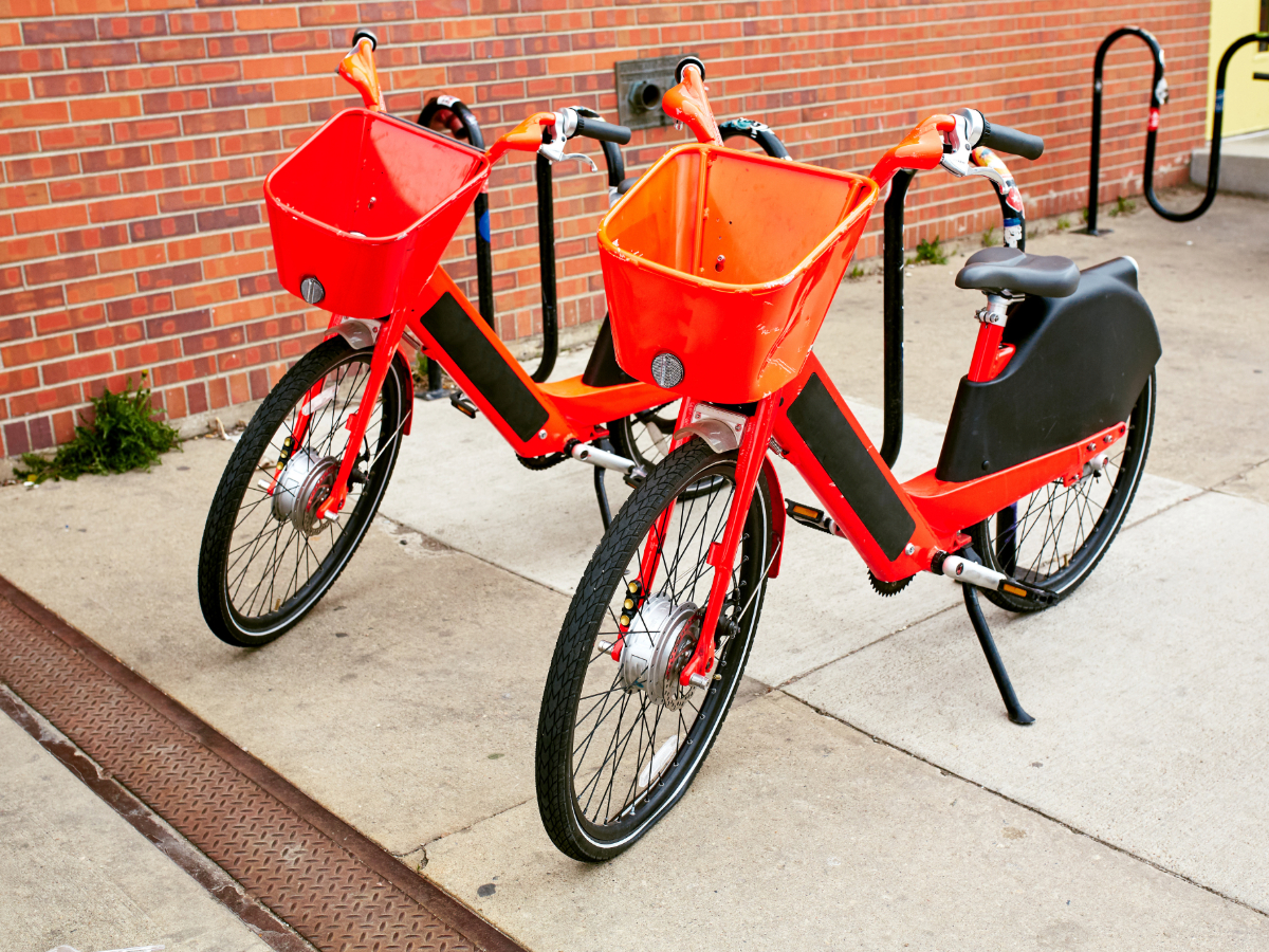 2 red bikes with baskets parked on sidewalk in RiNo district for article Discovering the Most Unique Neighborhood in Denver for newcomers moving to Denver.