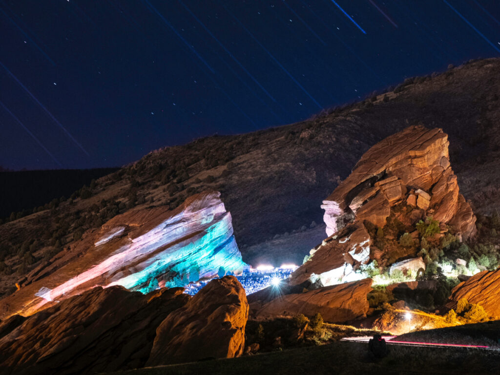 Red Rocks amphitheatre at night with the rocks glowing with lights for article 5 Unforgettable Outdoor Adventures in Denver for Newcomers moving to denver.