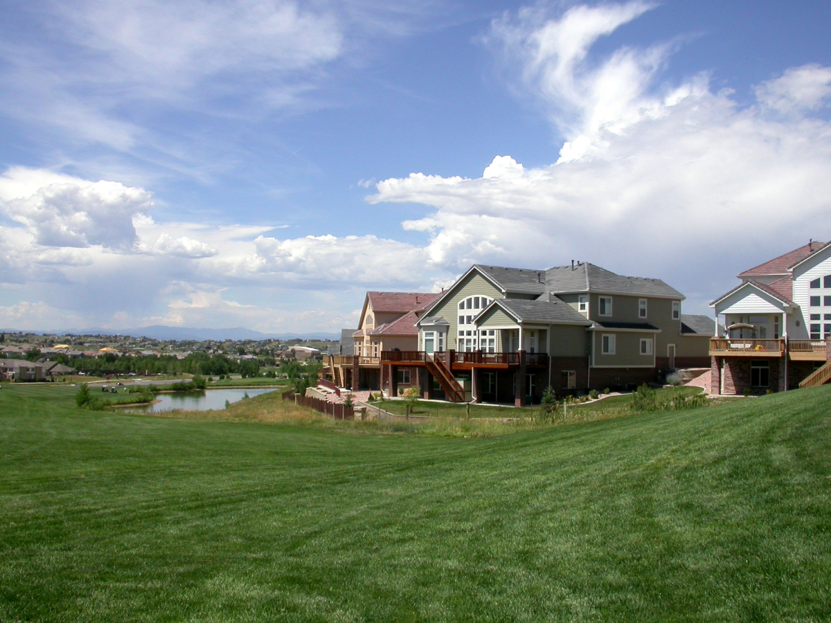 Aurora, Colorado - houses in the background with green grass on a hill for article Aurora, Colorado: The World in a City for newcomers moving to Denver.