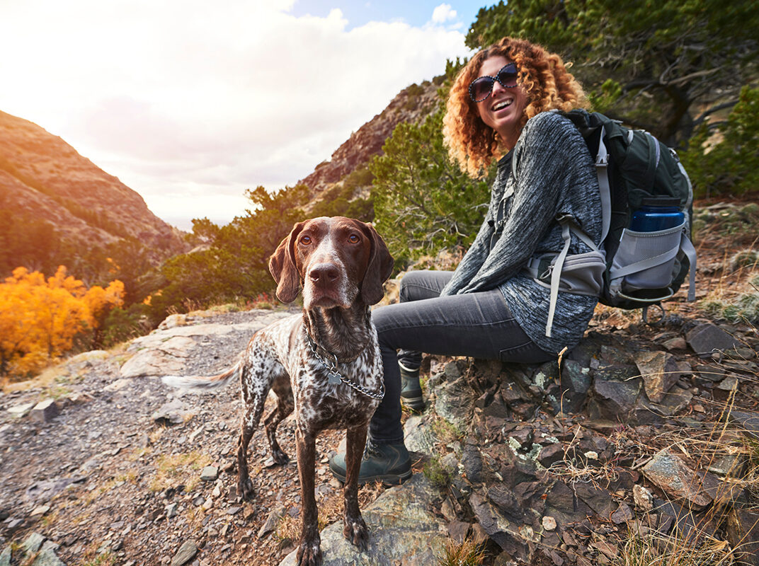 Women with dog on a mountain trail. Credit Union of Colorado