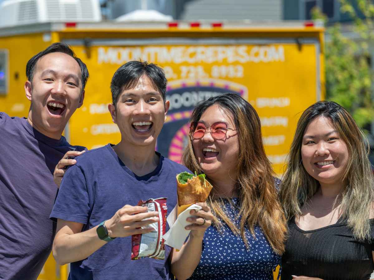 4 people posing together in front of food truck, having fun, and smiling for article Painted Prairie is Blossoming for newcomers moving to DFW.