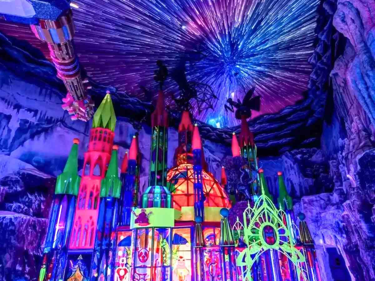 Image of Meow Wolf depicting colorful castle with immersive bright lights on every part of the room including burst of lights on ceilings in blues, purples, greens, pinks for article 10 Quirky and Unusual Things to Do in Denver for newcomers moving to Denver.