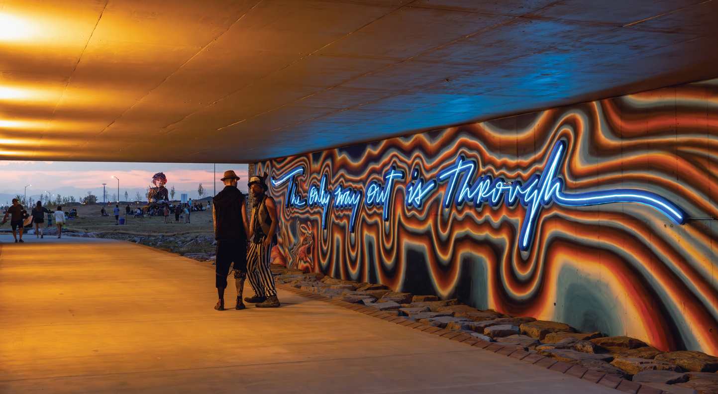 Tunnel with walls painted and long/large neon lettering that says the only way out is through for article The Aurora Highlands Named Denver’s Community of the Year for newcomers moving to Denver.