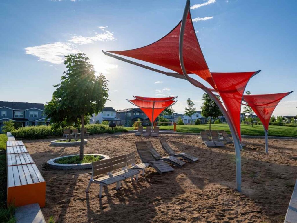 One of Painted Prairie's covered spaces using red triangular shade sails over seats in outdoor seating area for article 