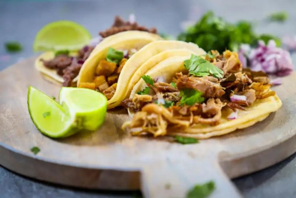 Close up of soft tacos on wood platter with limes at EnFuego Cantina for article Aurora, Colorado: The World in a City for newcomers moving to Denver or relocating within Denver.