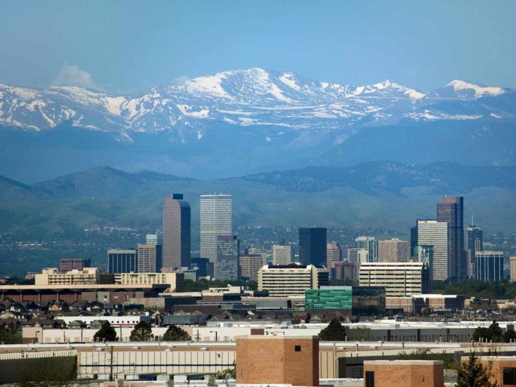 Denver skyline with mountains in the background for article Cost of Living in Denver vs Other Top Cities for newcomers moving to Denver.