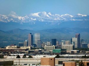Denver skyline with mountains in the background for article Cost of Living in Denver vs Other Top Cities for newcomers moving to Denver.