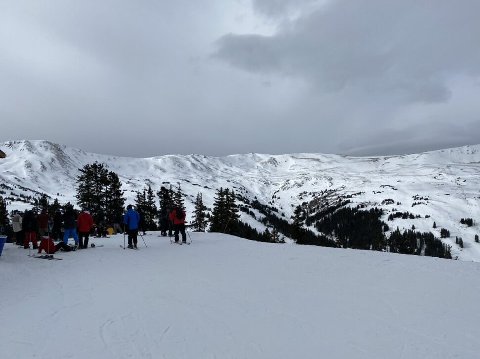 Skiers on a mountain top - COlorado ski resorts